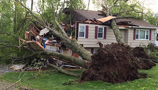 Emergency storm restoration service team repairing home after severe storm damage.